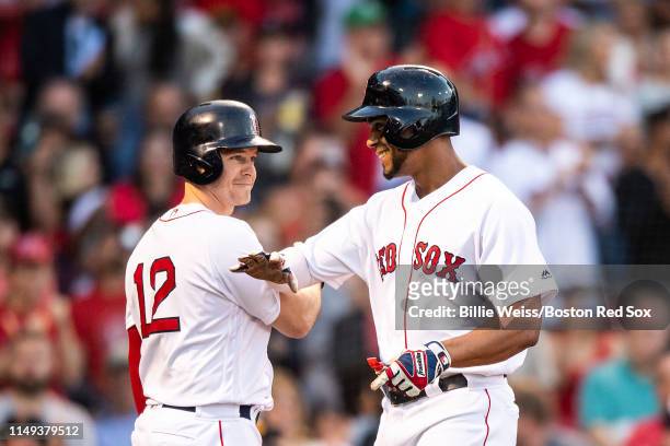 Xander Bogaerts of the Boston Red Sox reacts with Brock Holt after hitting a solo home run during the first inning of a game against the Texas...