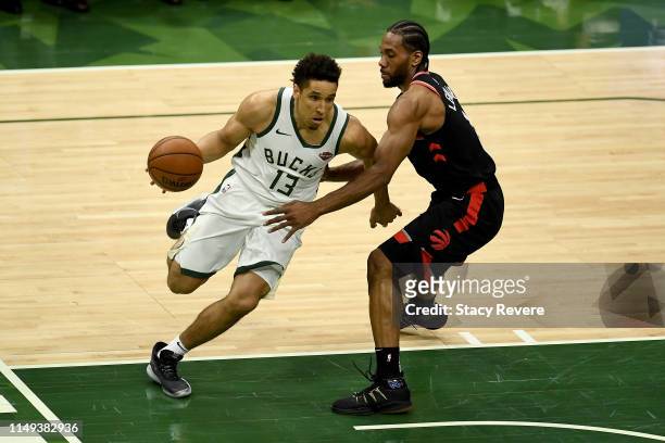 Malcolm Brogdon of the Milwaukee Bucks dribbles the ball while being guarded by Kawhi Leonard of the Toronto Raptors in the second quarter in Game...