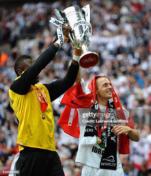 Garry Monk of Swansea lifts the trophy alonside Yves Ma-Kalambay as they celebrate promotion to the Premier League during the npower Championship...