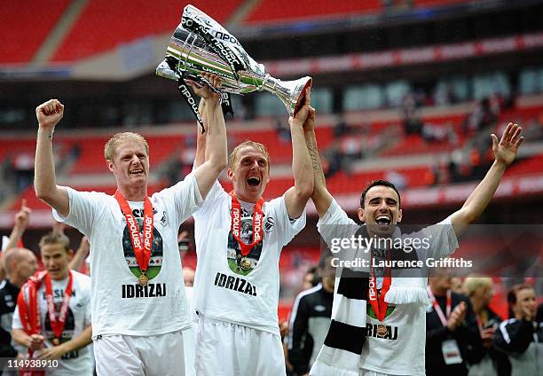 Garry Monk of Swansea lifts the trophy as they celebrate promotion to the Premier League with Alan Tate and Leon Britton during the npower...