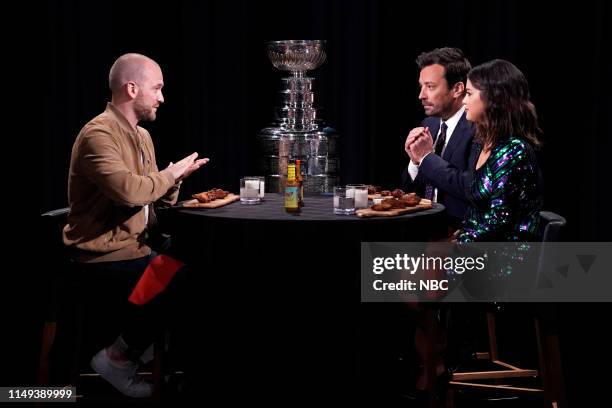 Episode 1078 -- Pictured: Interviewer Sean Evans, the Stanley Cup, host Jimmy Fallon, and singer Selena Gomez during "Hot Ones" on June 11, 2019 --