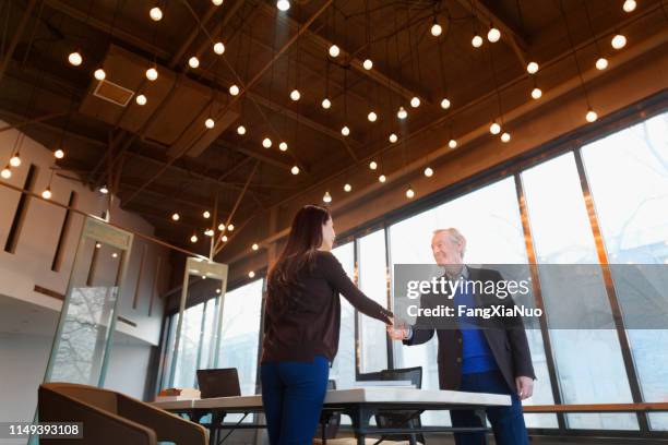man and woman shaking hands in design office - day 1 stock pictures, royalty-free photos & images