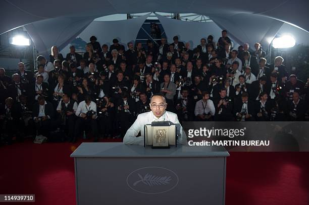 Thai director Apichatpong Weerasethakul poses after receiving the Palm d'Or award for his film "Lung Boonmee Raluek Chat" during the photocall of the...