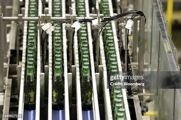 Bottles of Heineken NV brand beer, featuring labels with the Web Ellis Cup, move along the production line of a Kirin Brewery Co. Factory in...