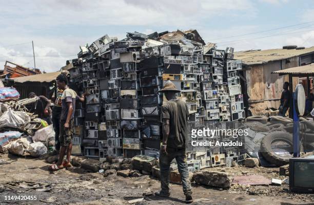 African men disassemble electronic scrap and bulky waste on the largest electronic scrap yard of Africa in Agbogbloshie, a district of Ghana's...