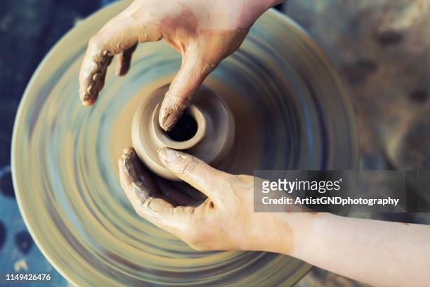 nahaufnahme der weiblichen hände, die auf dem töpferrad arbeiten. - keramiker stock-fotos und bilder