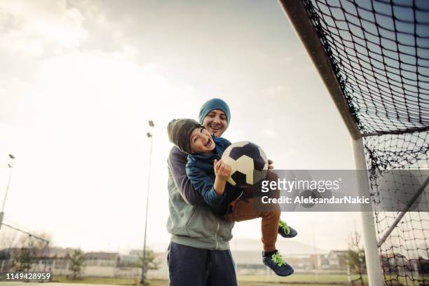 vader en zoon voetbal buitenshuis - voetbalcompetitie sportevenement stockfoto's en -beelden
