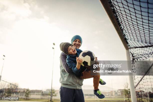 father and son playing soccer outdoors - parents cheering stock pictures, royalty-free photos & images