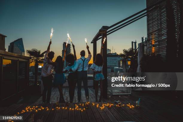 friends partying on a rooftop - rooftop party night stock pictures, royalty-free photos & images