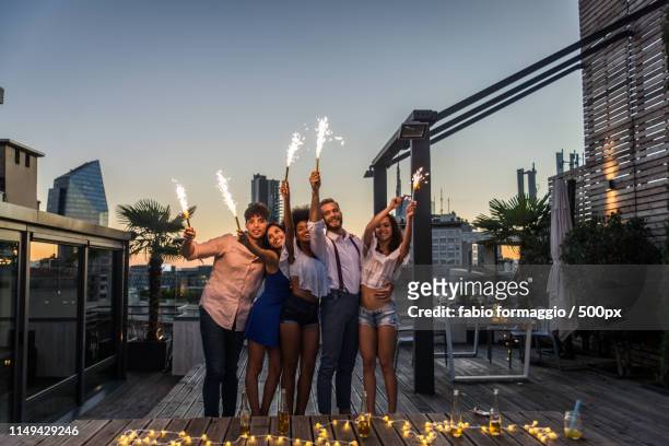 friends partying on a rooftop - pool party night stock pictures, royalty-free photos & images