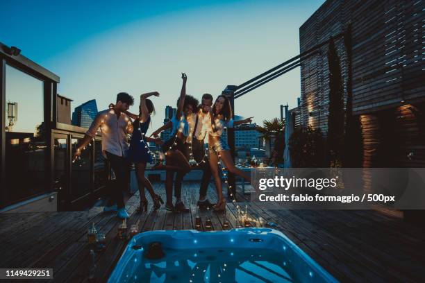 friends partying on a rooftop - beer luxury stock-fotos und bilder