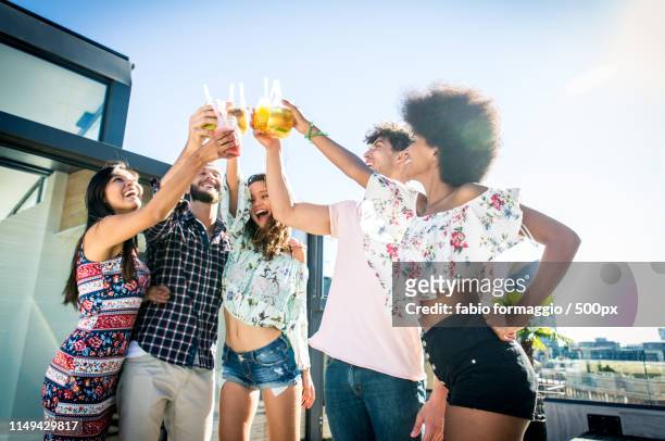 friends partying on a rooftop - rooftop pool stock-fotos und bilder