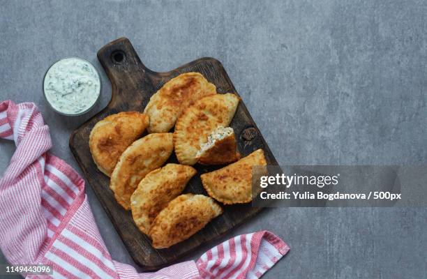 spanish and latin american fried empanadas with sauce on the grey stone background, top view - beef empanadas stock pictures, royalty-free photos & images