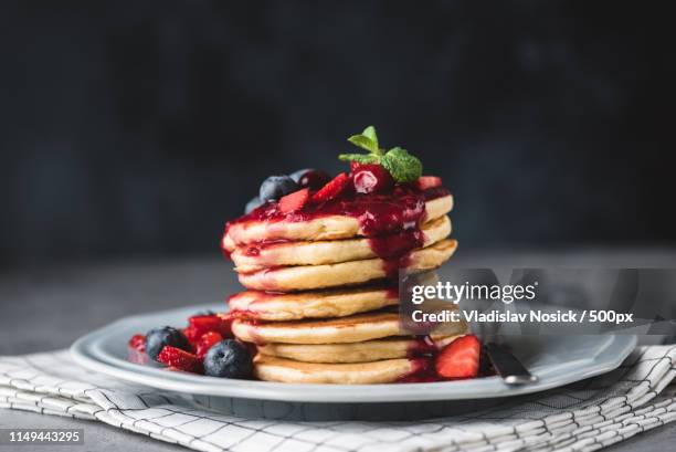 pancakes with berry sauce and berries - maslenitsa stock pictures, royalty-free photos & images