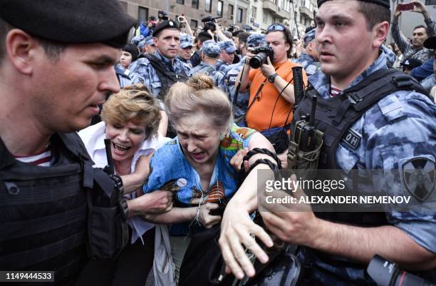 Russian police officers detain protesters during a march to protest against the alleged impunity of law enforcement agencies in central Moscow on...