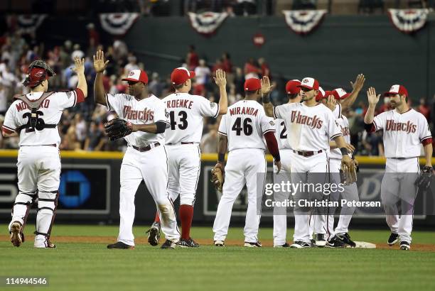 Justin Upton of the Arizona Diamondbacks high-fives teammate Miguel Montero after defeating the Florida Marlins in the Major League Baseball game at...