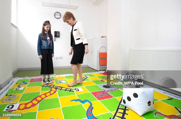 First Minister Nicola Sturgeon plays a 'snakes and ladders' game with Ava Dewar during a visit to the Dundee Carers Centre in Dundee on June 12, 2019...