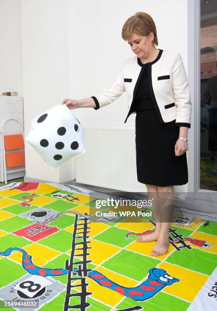First Minister Nicola Sturgeon plays a 'snakes and ladders' game during a visit to the Dundee Carers Centre in Dundee on June 12, 2019 in Dundee,...