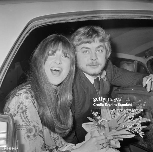 British broadcaster and journalist Cathy McGowan and Welsh actor Hywel Bennett sit in the back of a car on their wedding day, UK, 17th January 1970.
