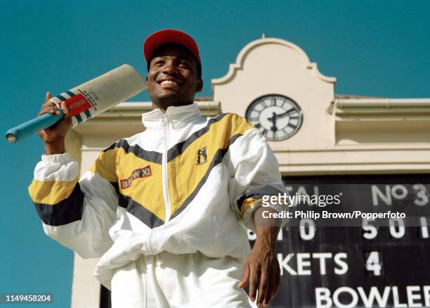 Brian Lara of Warwickshire stands in front of the scoreboard showing his record score of 501 not out at the end of the Britannic Assurance County...