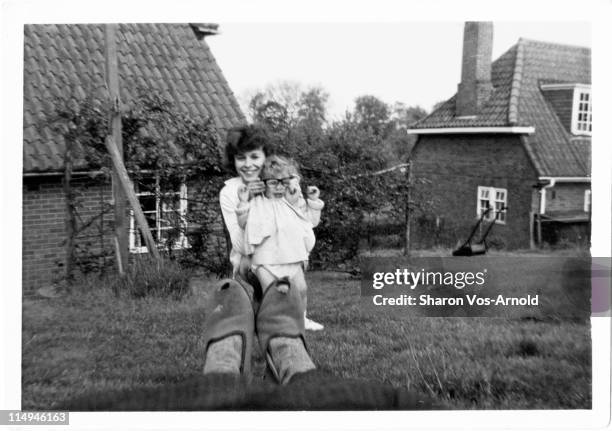 young woman and toddler wearing glasses - retro portrait frau mother stock-fotos und bilder