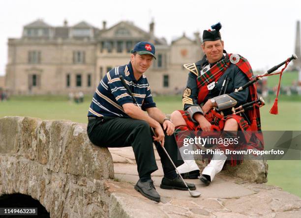 Australian cricketer Steve Waugh sits on the Swilcan Bridge at the St Andrews Golf Club with a piper during a golf day for the Australian Cricket...