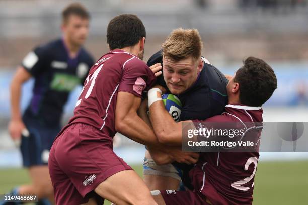 Tom Marshall of Scotland U20 is tackled by Mikehil Alani and Tedo Abzhandadze of Georgia U20 during a Pool C match between Georgia U20 and Scotland...