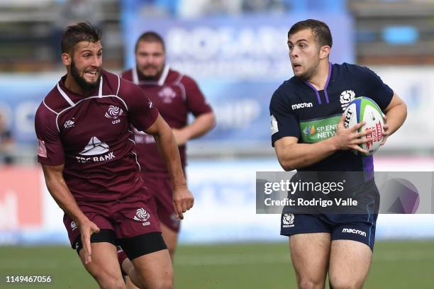 Robbie McCallum of Scotland U20 runs with the ball under pressure of Demur Tapladze of Georgia U20 during a Pool C match between Georgia U20 and...