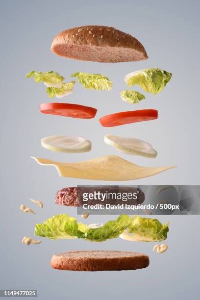 classic beef burger with onion floating on gray background - throwing tomatoes stock pictures, royalty-free photos & images