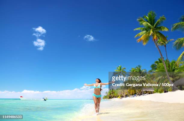 carefree young woman relaxing on tropical beach - punta cana stock pictures, royalty-free photos & images