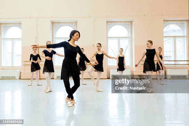 ballerine a scuola che praticano con insegnanti che mostrano pose - dance teacher foto e immagini stock