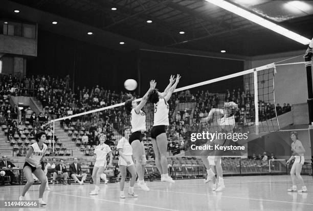 Jean Gaertner of the United States attempts to spike the ball against the defence of Doina Popescu and Ileana Enculescu of Rumania during their...