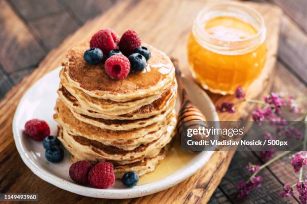 oat pancakes with berries and honey - blueberry pancakes stock-fotos und bilder