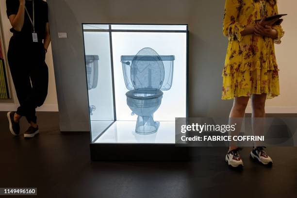 Visitors stand next to an artwork by Do Ho Suh entitled "Toilet, Apartment A, 348 West 22nd Street, New York, NY 10011, USA" at the Lehmann Maupin...