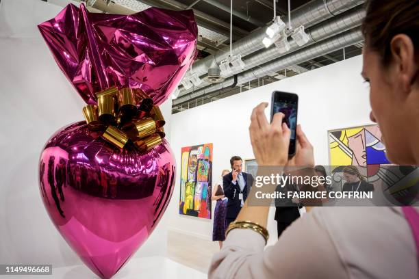 Visitor takes a picture of an artwork by Jeff Koons entitled "Sacred Heart " at the Gagosian gallery exhibition space during a preview day of Art...