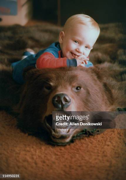 baby boy on bearskin rug - bear lying down stock pictures, royalty-free photos & images