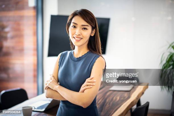 confident asian businesswoman in office - chinese ethnicity stock pictures, royalty-free photos & images