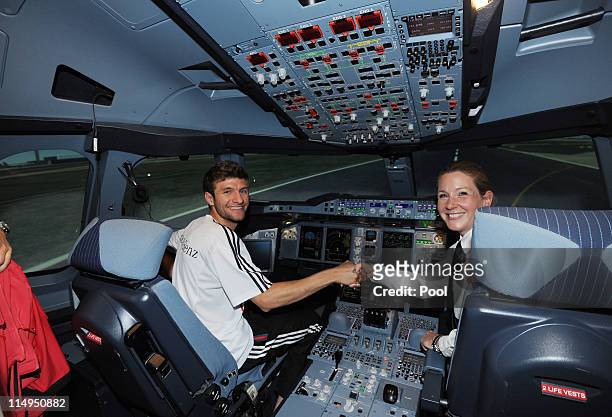 Thomas Mueller of Germany shakes hands with Captain Kerstin Felser in a flight simulator of airbus A380 at the Airport Frankfurt Lufthansa Flight...