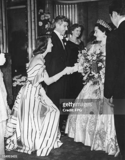 American actress Loretta Young curtsies to the Queen Mother at the Royal Command Film Performance at the Odeon Leicester Square, London, November...