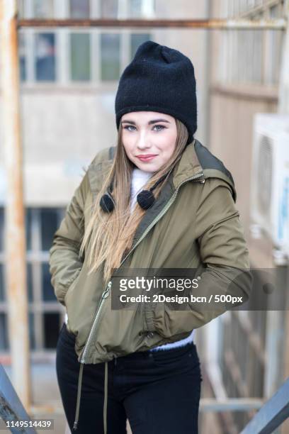 front view of a young teen standing outdoors with hands on pocke - three quarter length stock-fotos und bilder