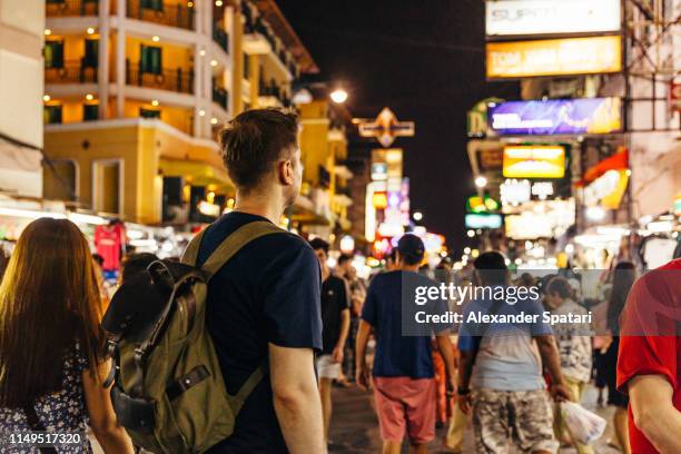 rear view of a tourist at khao san road in bangkok, thailand - hostel people travel stock-fotos und bilder