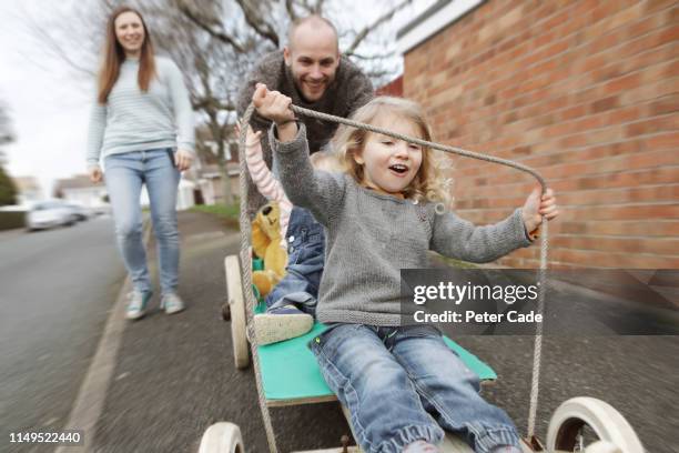 family with two children playing on go kart - two kids playing with hose stock-fotos und bilder