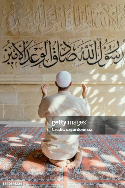 muslim man is praying in mosque - islamismo imagens e fotografias de stock