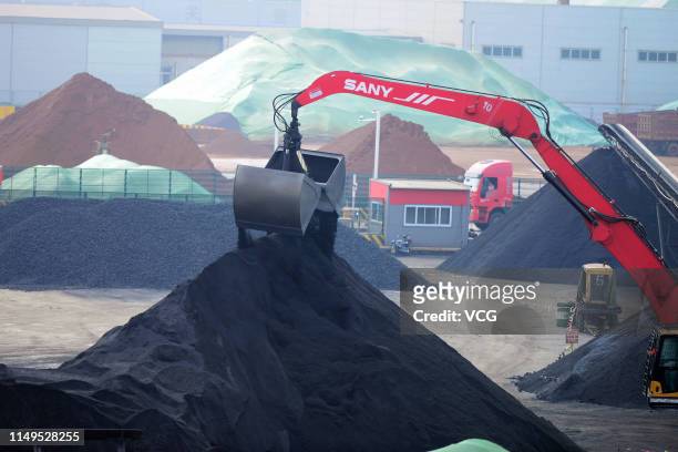 Grab bucket unloads imported iron ore on a quay at the Rizhao Port on May 15, 2019 in Rizhao, Shandong Province of China. Imported iron ore were...
