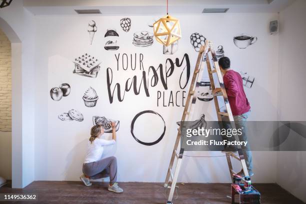 gemotiveerde paar doen wat nodig home improvement - painted wall stockfoto's en -beelden