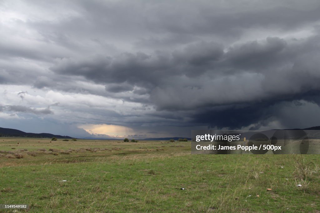 Gray storm clouds over green field