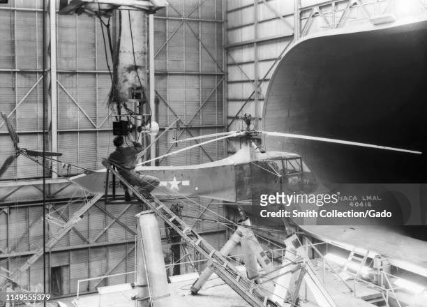 Technician sets up camera equipment on the Langley's Sikorsky YR-4B/HNS-1 helicopter in the 30 x 60 Full-Scale Tunnel at Langley Research Center,...