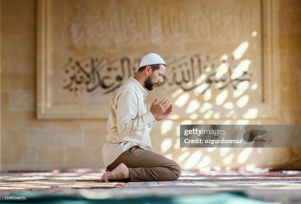 Muslim man is praying in mosque