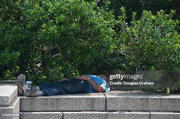 May 31: A man catches a "cat nap' in the shade near the fountain in the Upper Senate Park of the U.S. Capitol. Temperatures in the District reached...