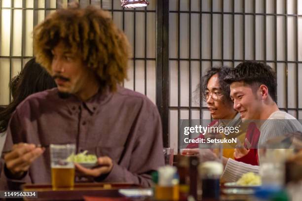 friends traveling in japan, drinking at izakaya - izakaya stock pictures, royalty-free photos & images